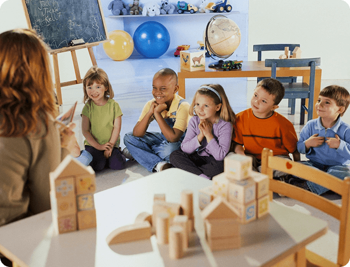 A group of children sitting in front of a table.