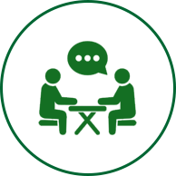 Two people sitting at a table with one of them talking.